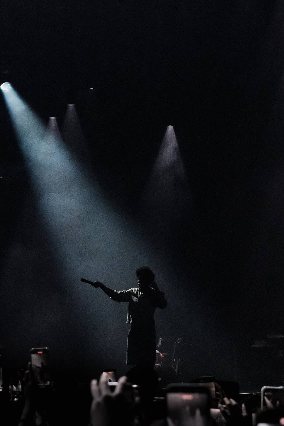 Performer silhouetted under crossed stage beams