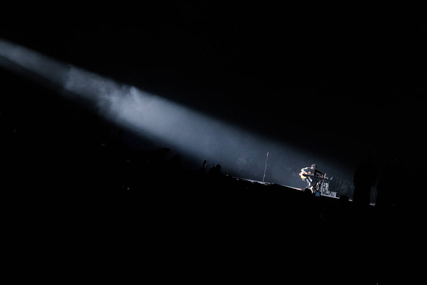 A single performer caught in a narrow beam of stage light